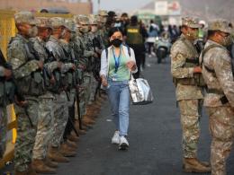 mujer_caminando_entre_militares_toque_de_queda_en_peru.jpg