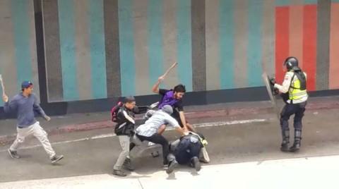 18 de mayo: Violentos opositores agreden a un policía. Foto: Telesur pegando un policia telesur mobile